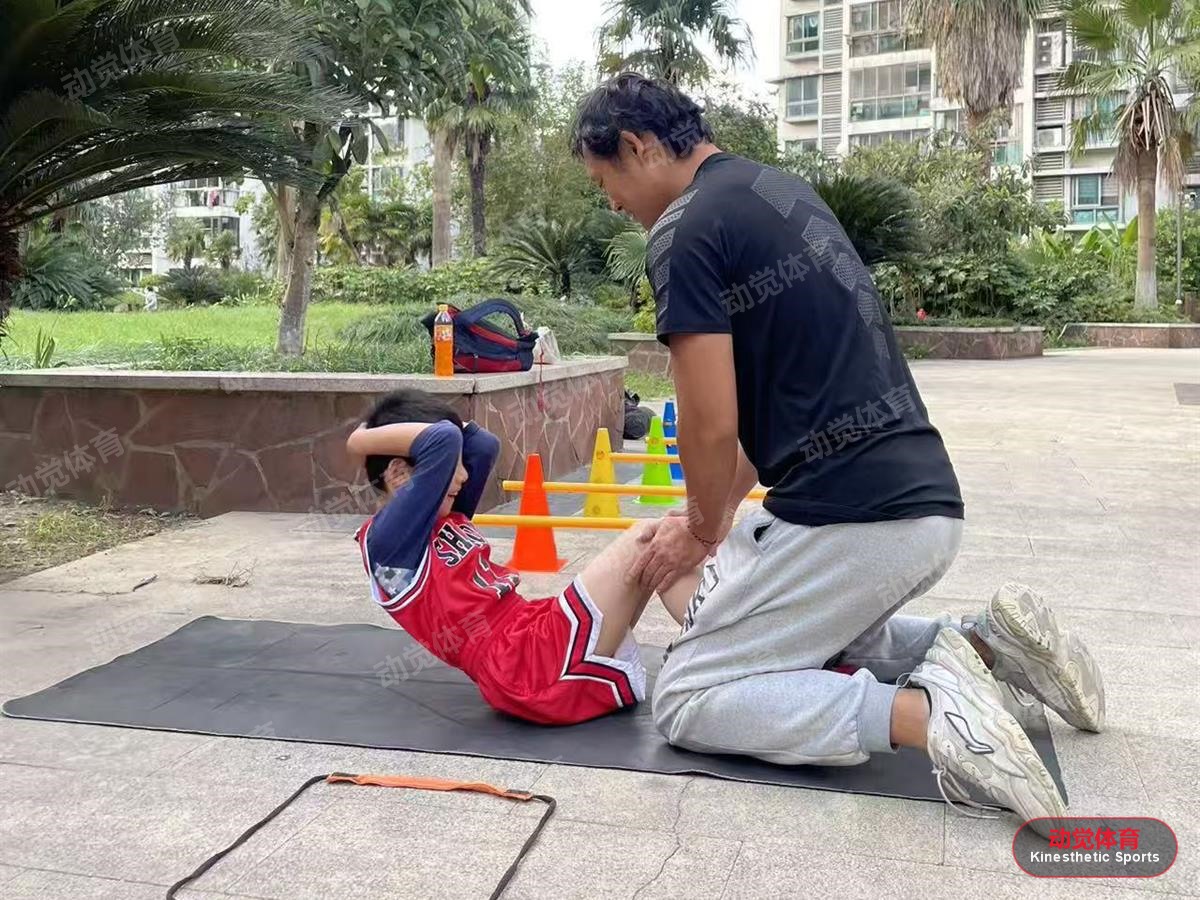 教练在小区指导孩子进行核心力量训练