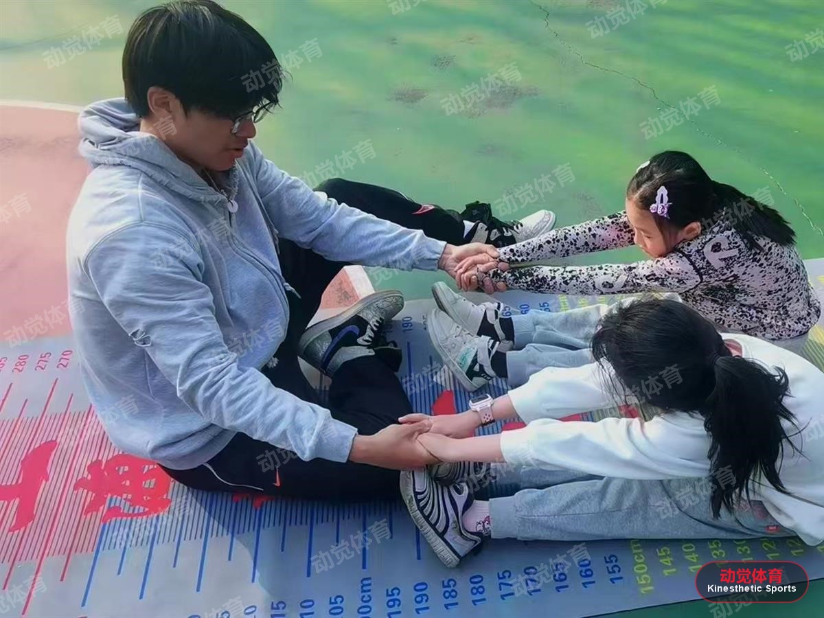 教练带领孩子进行坐位体前屈训练