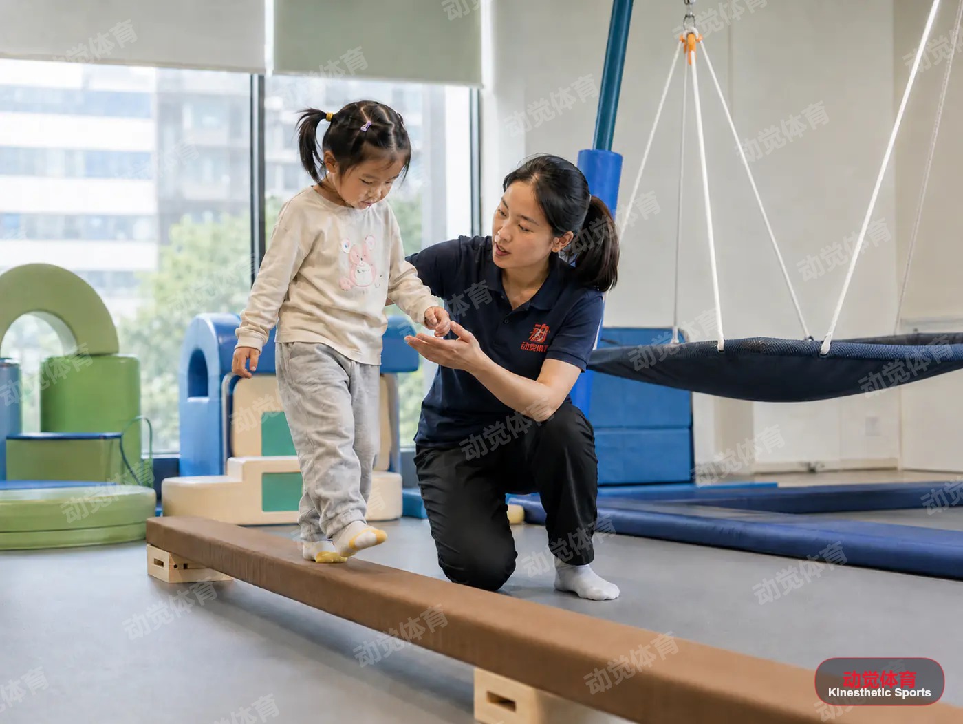 教练引导幼儿在平衡木上进行感统协调训练